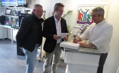 Trois professionnels discutant devant un comptoir de services informatiques.